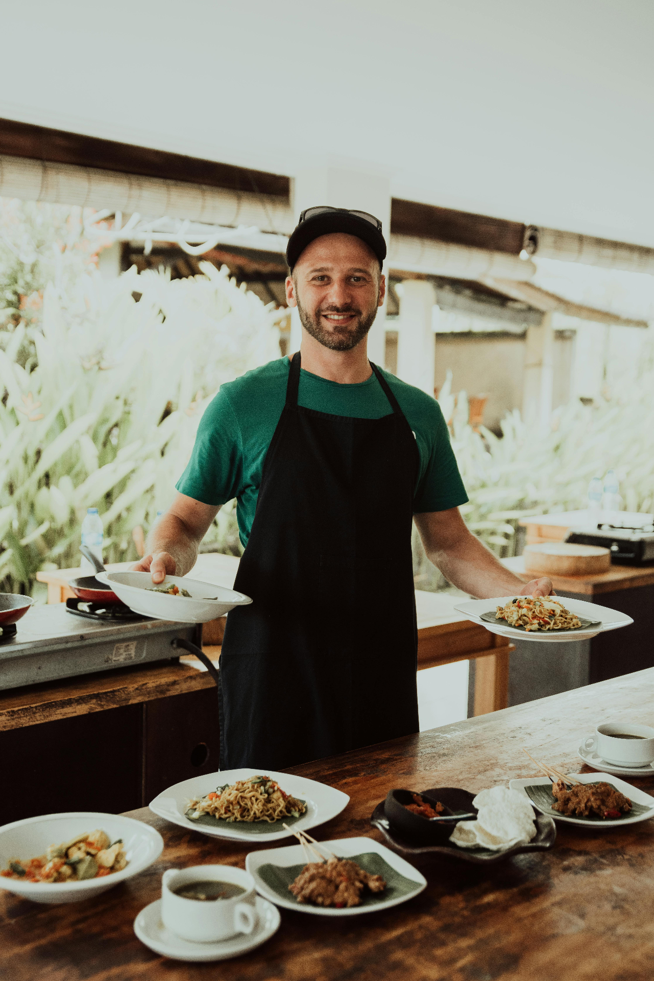 Chef presenting multiple dishes in kitchen